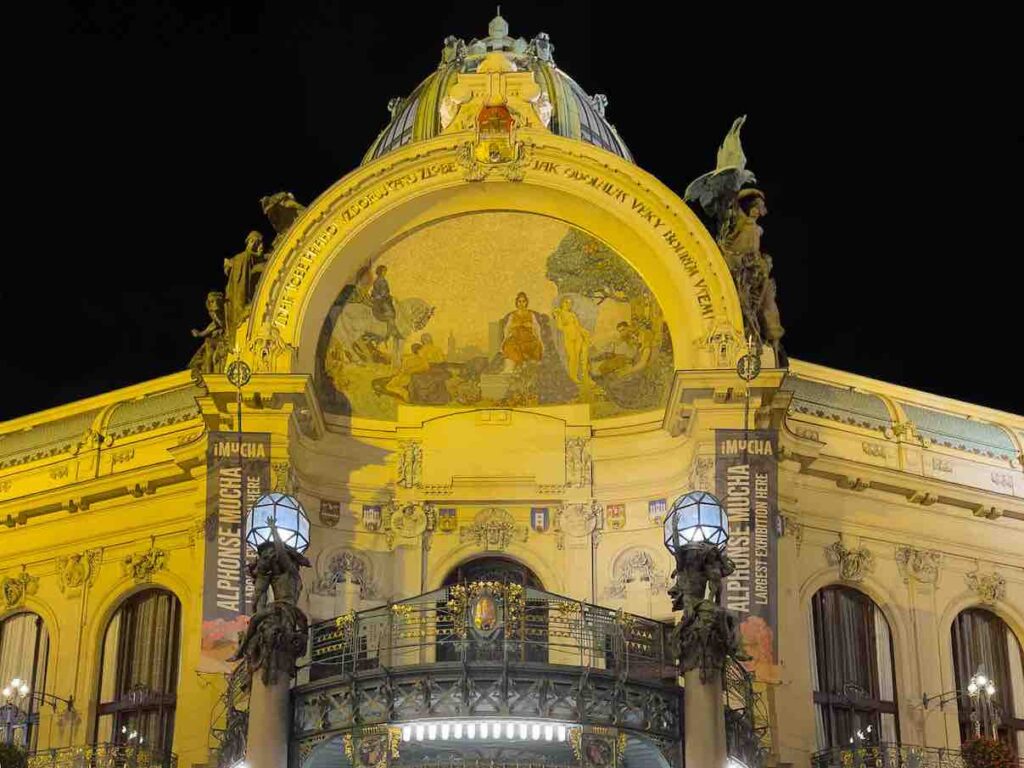 Fachada da Casa Municipal de Praga iluminada a noite.
